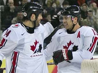 Джером Игинла (справа) принимает поздравления от Тодда Бертуцци после того, как забил первую шайбу сборной Канады на Олимпиаде в Турине. Фото AFP